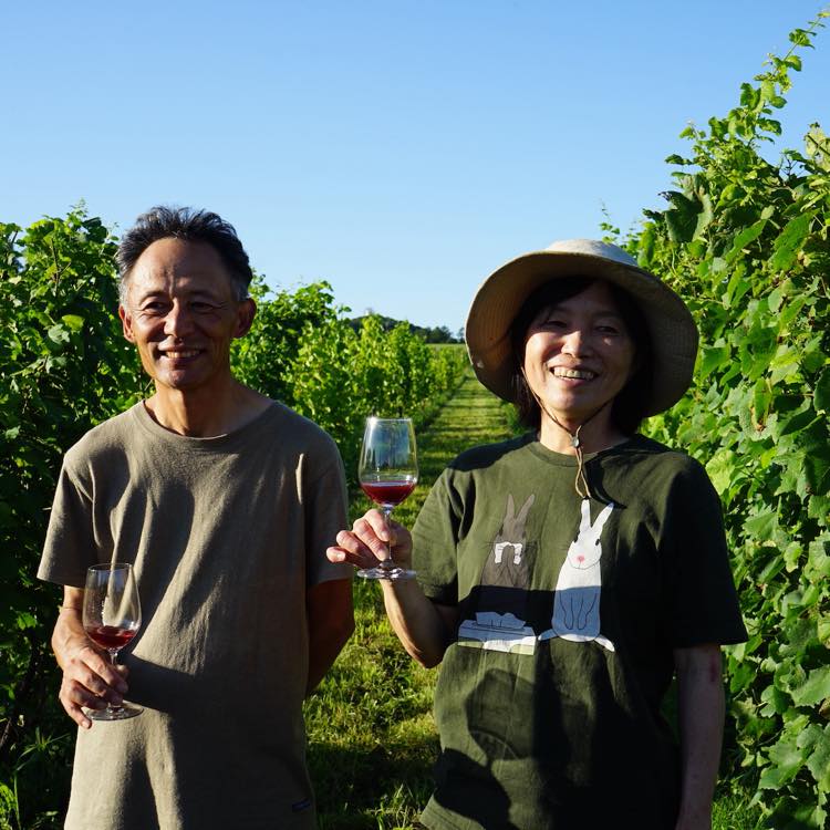 中澤一行さん・由紀子さん夫妻がワインを片手に微笑みながら並んでいる