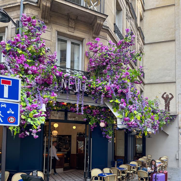 サンジェルマン・デプレの小さなカフェ「Le Nesle」の紫の造花が飾られた外観