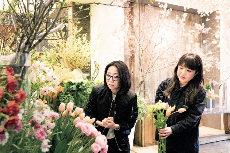 青木貴子さんと近江香朋里さんが『FUGA』の店内で花を選んでいる