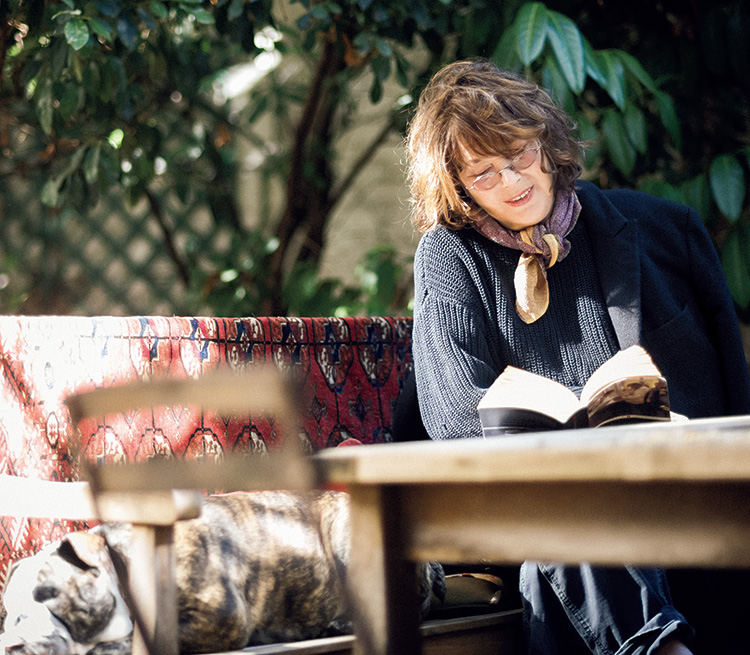 屋外ベンチで本を読むジェーン・バーキン