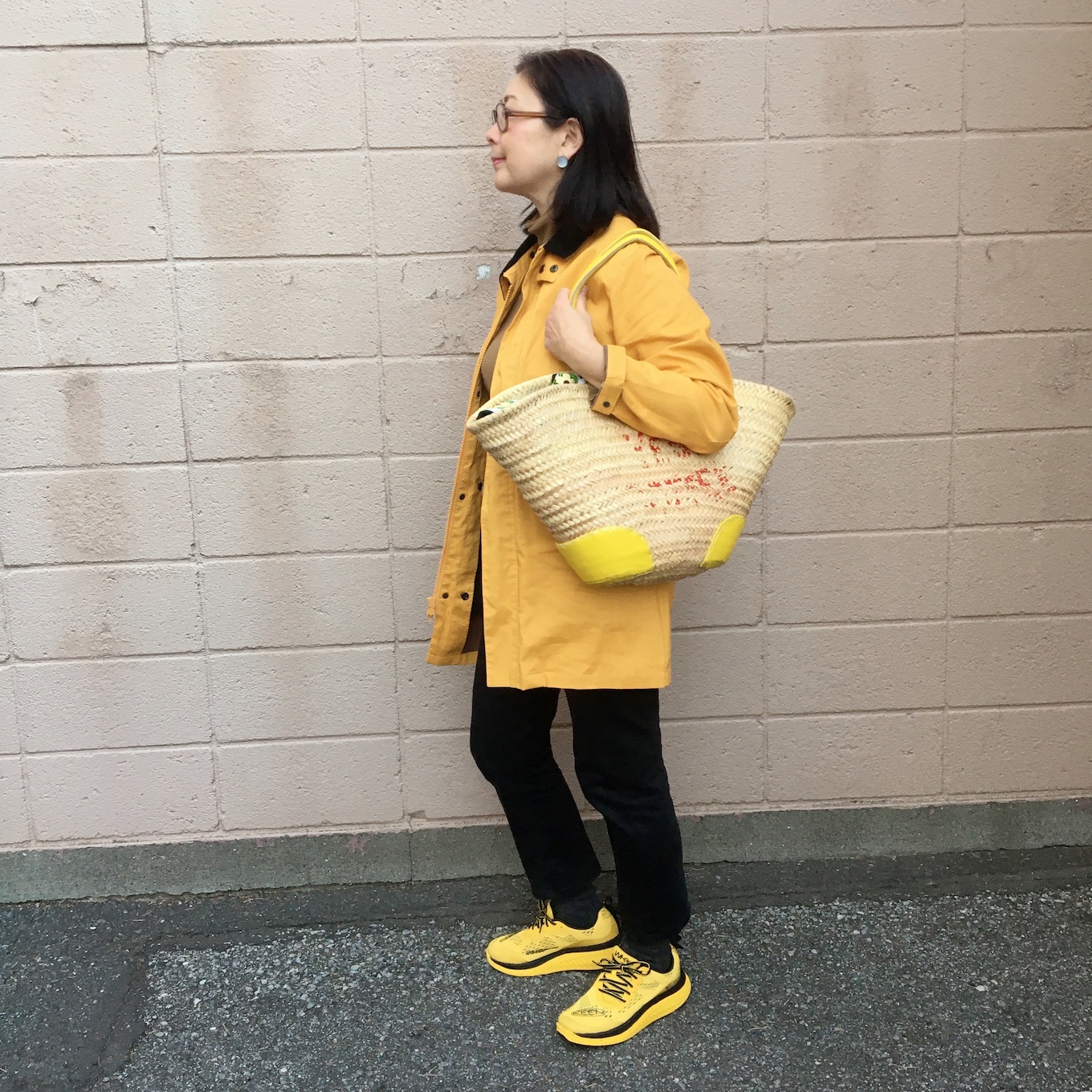 全身イエローコーデの石黒美穂子さんが横を向いている