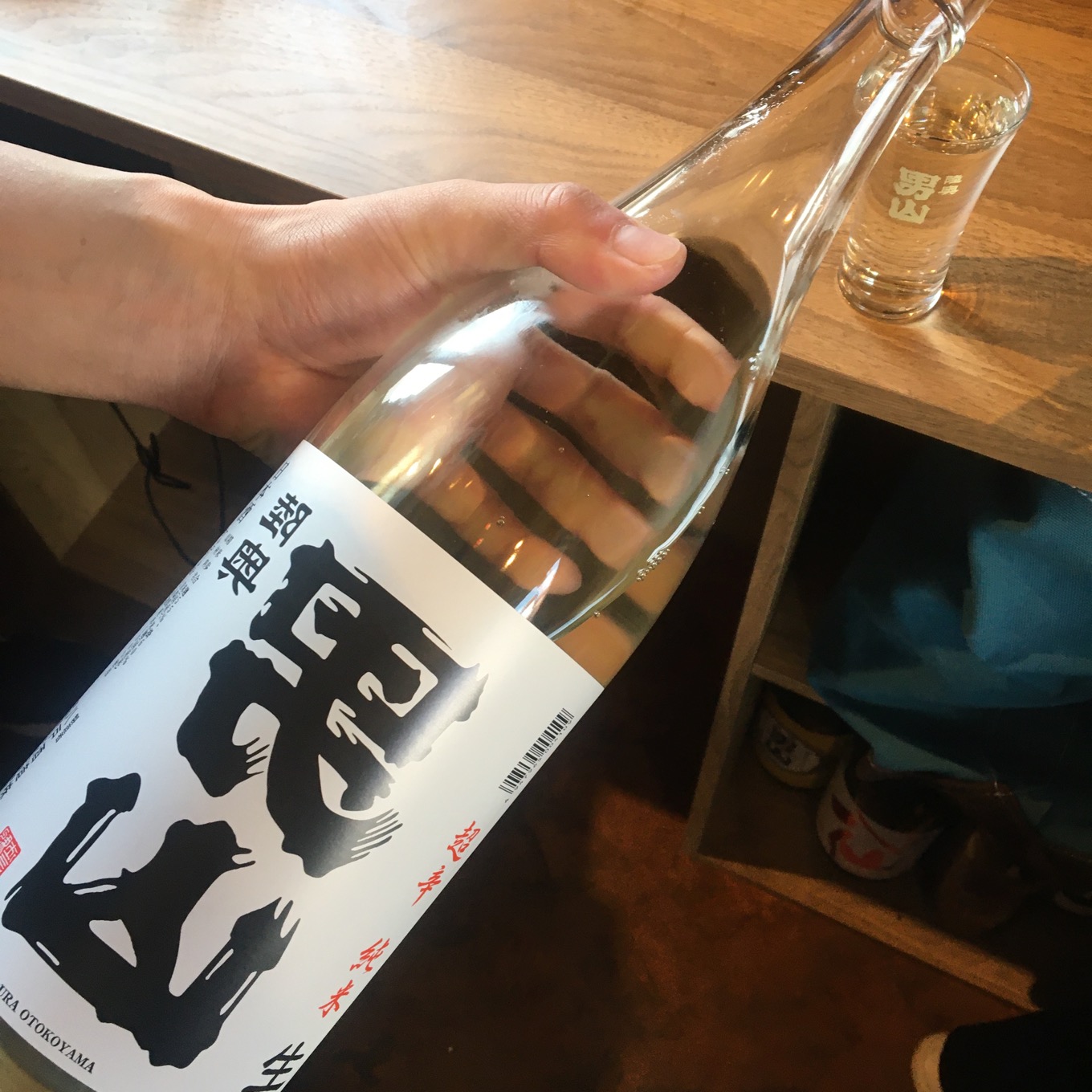 お酒の瓶を持っている右手