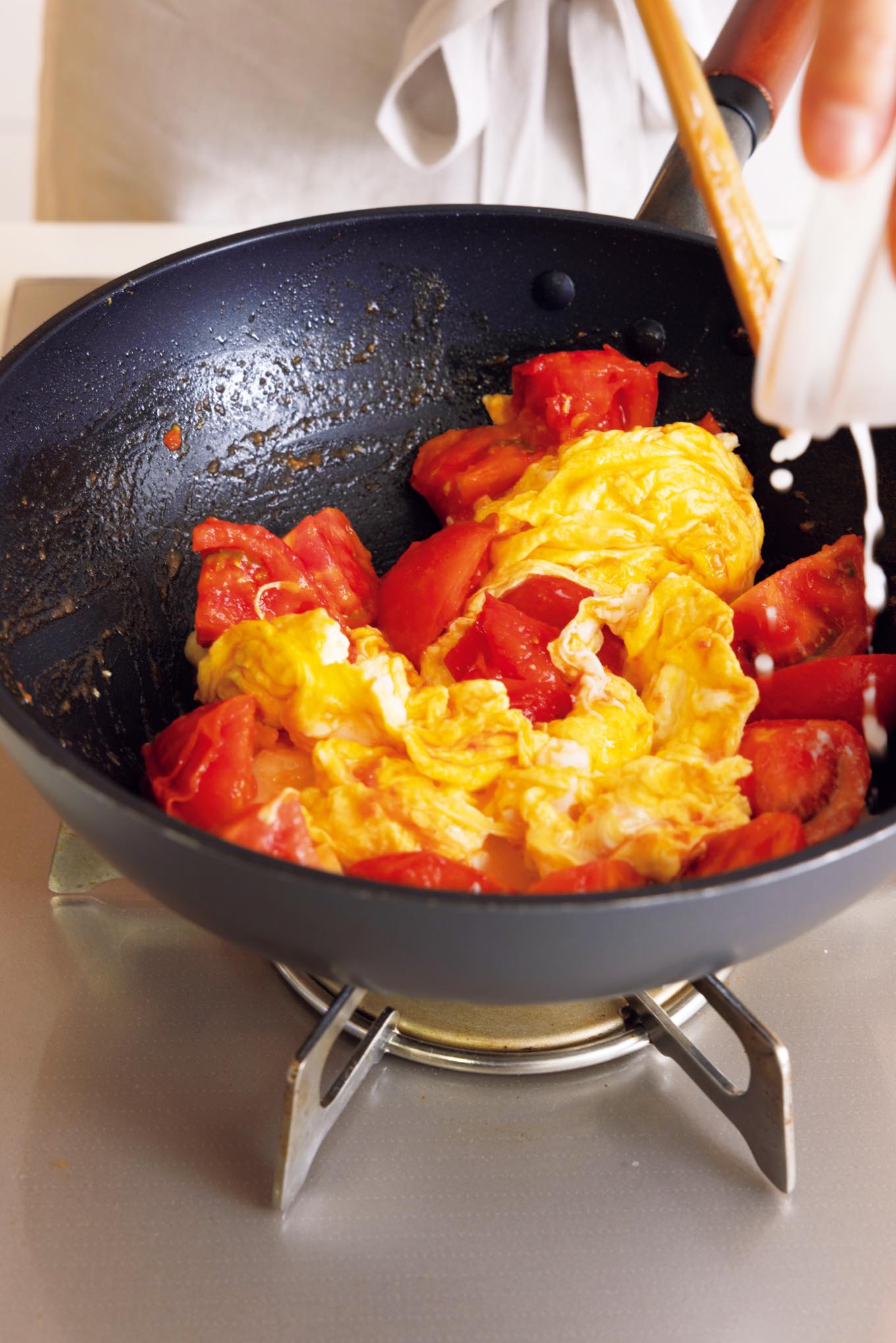 卵とトマトをフライパンで炒める