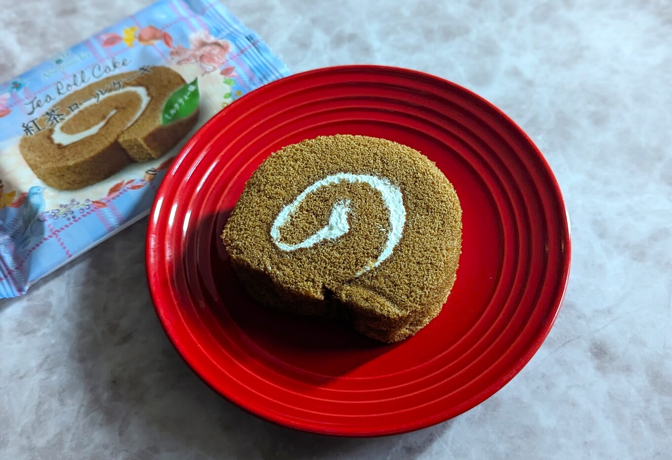 赤い皿の上の茶色いロールケーキ