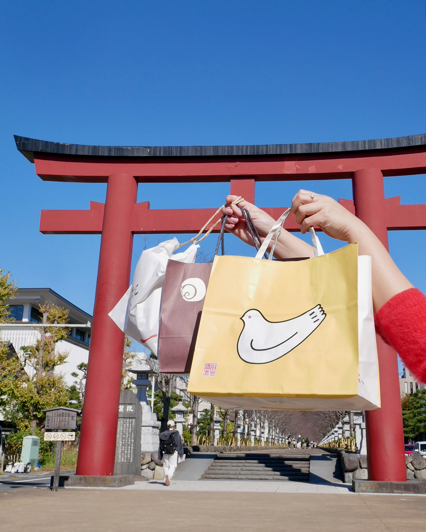 鎌倉土産 鳥居の前でバッグを持つ