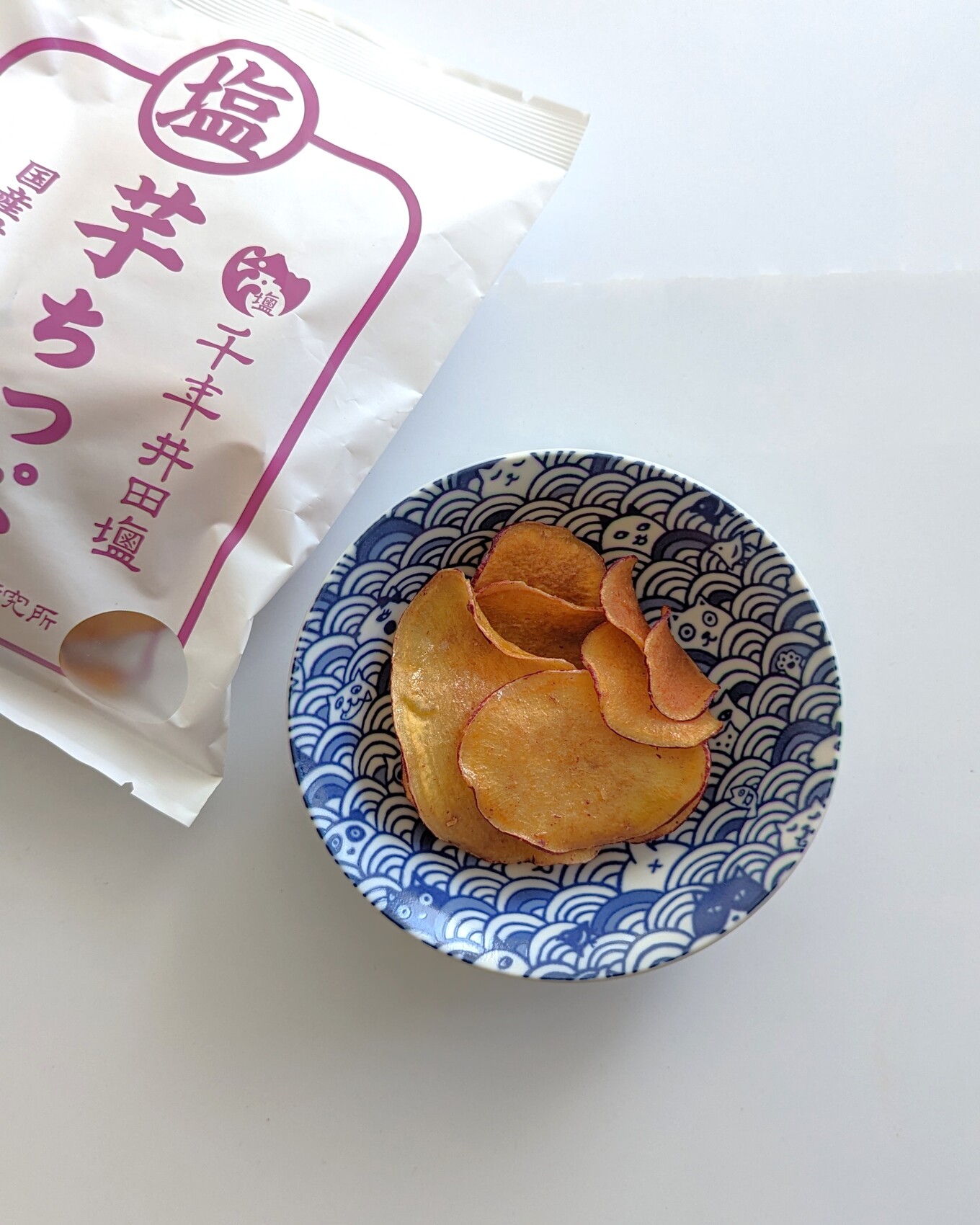 白いテーブルの上の青い器の中にある芋ちっぷ