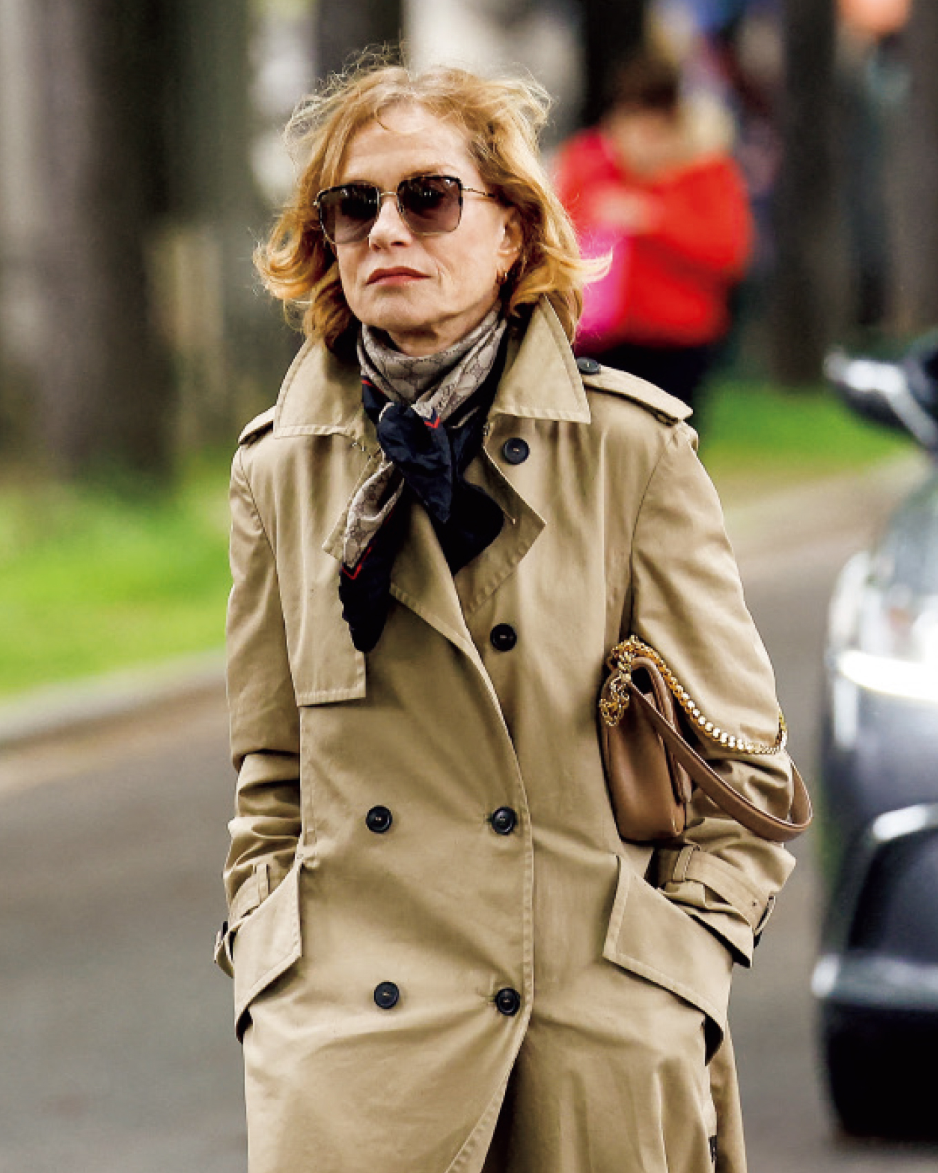 トレンチコートを着てサングラスをかけたイザベル・ユペール